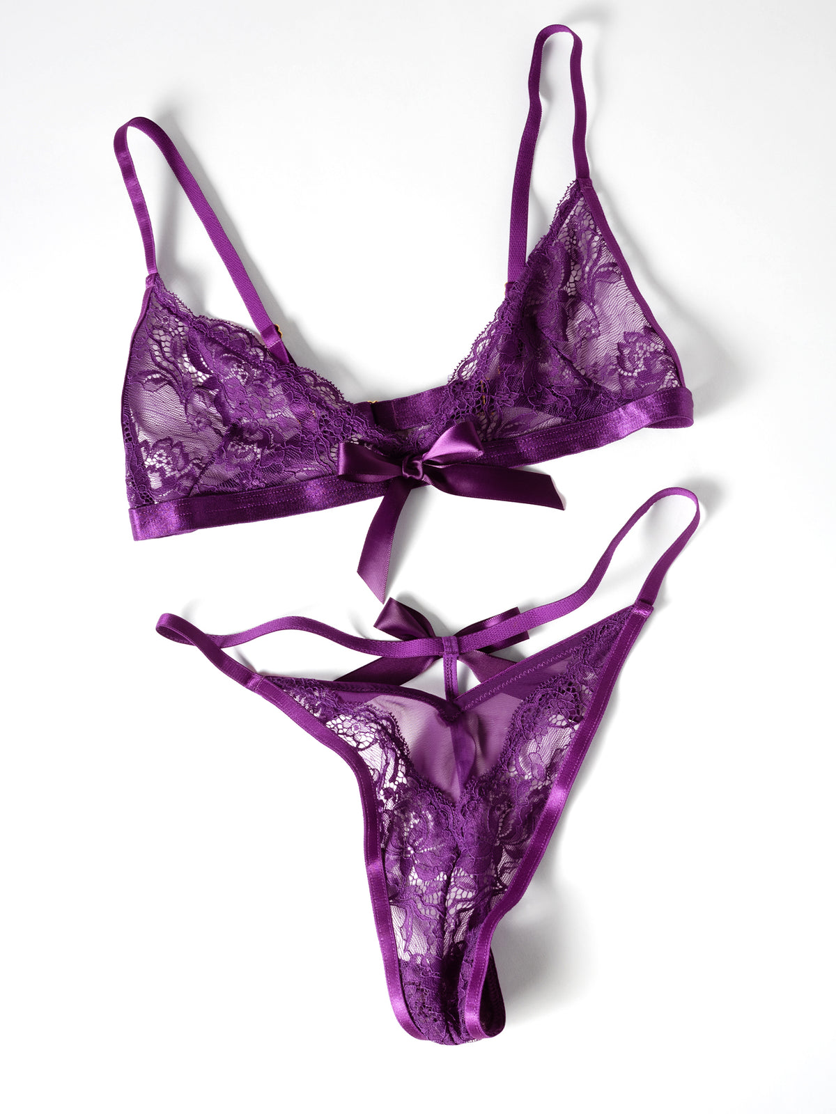 Flat lay of a Sylvie 2 piece lace bra set in imperial purple with wireless bra, V-shaped thong, and ribbon accents