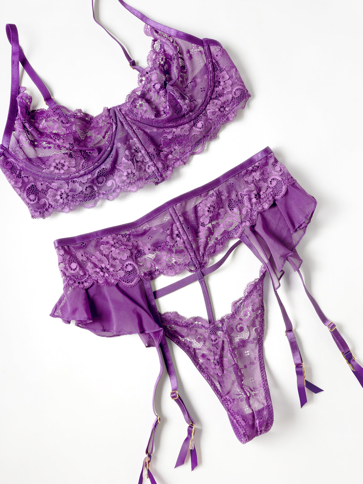 flat lay of a Harmony lace 3 piece bra set in imperial purple with underwire bra, G-string, and garter belt