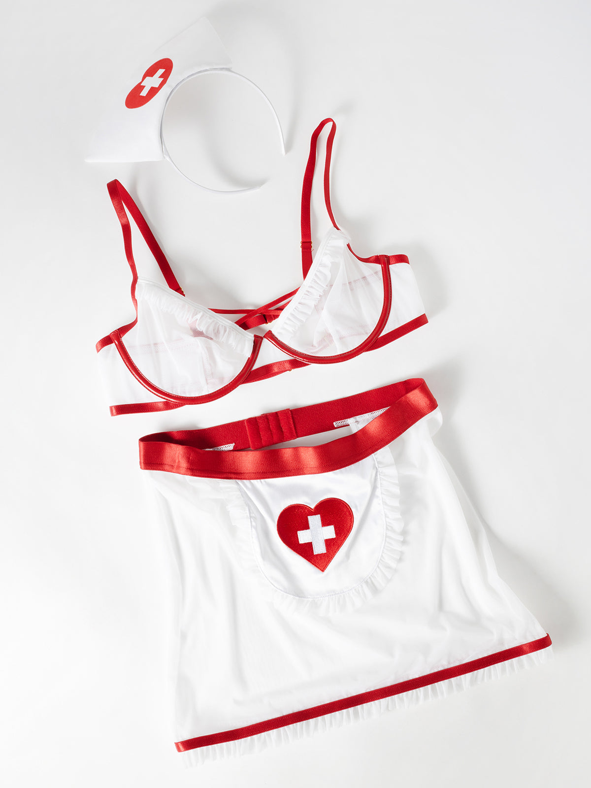 Flat lay of a White nurse outfit with red accents on a white background