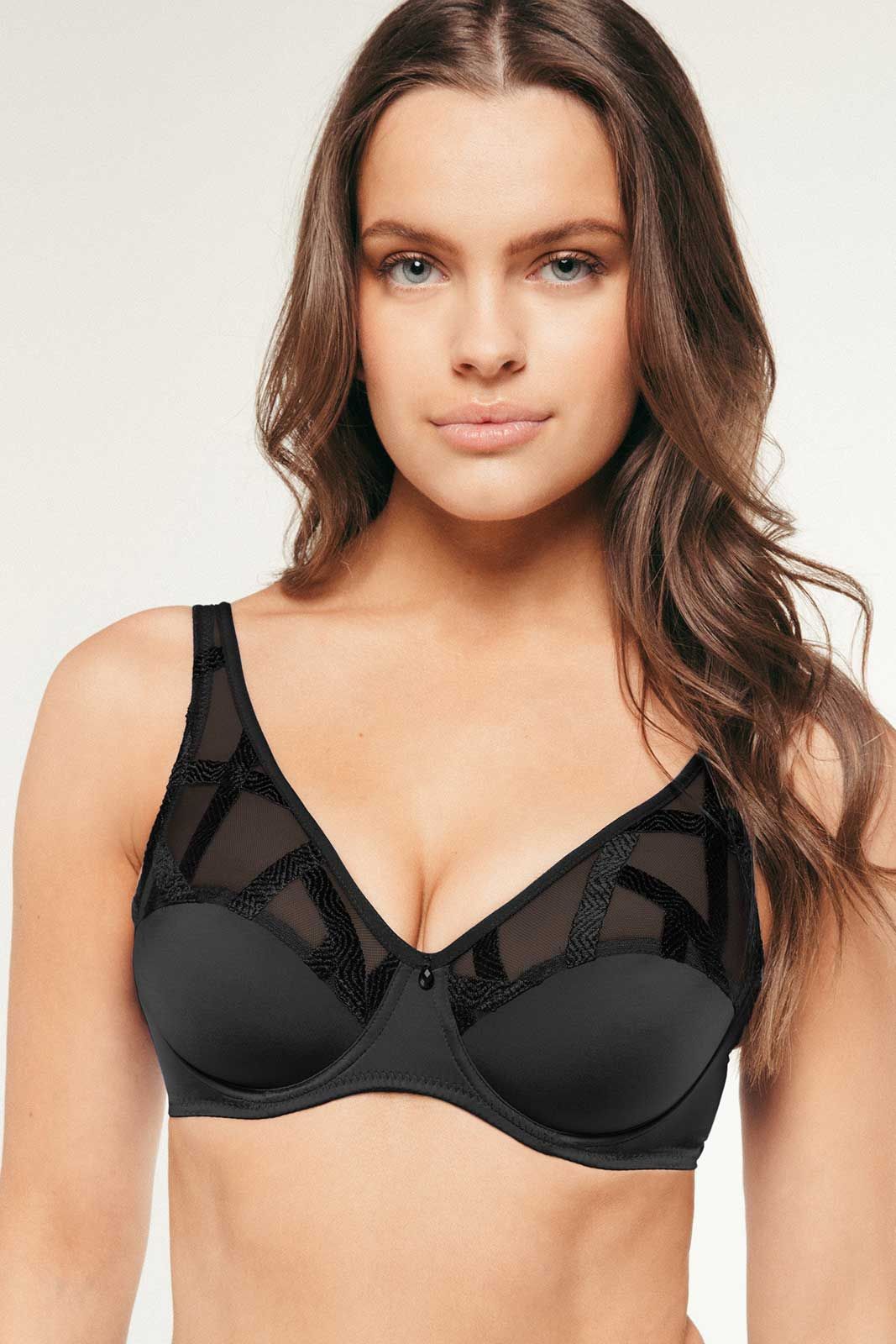 Woman wearing a black bra against a plain background