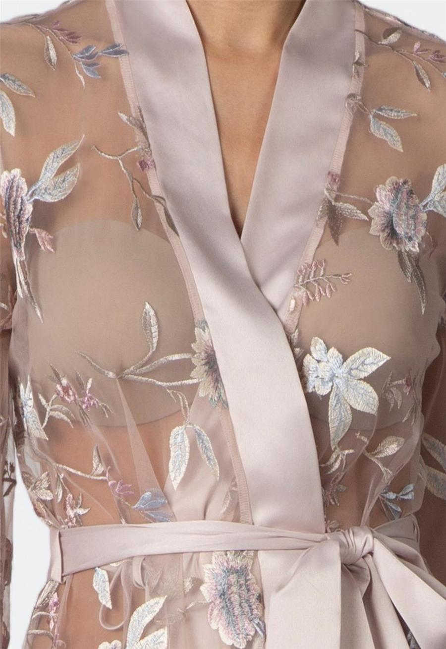 close up of a floral sheer sepia rose colored robe with a white background