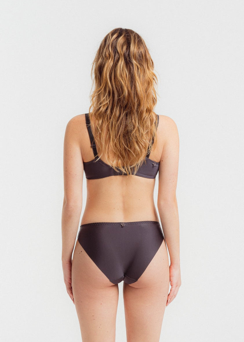 Woman wearing a dark gray bikini set on a white background

