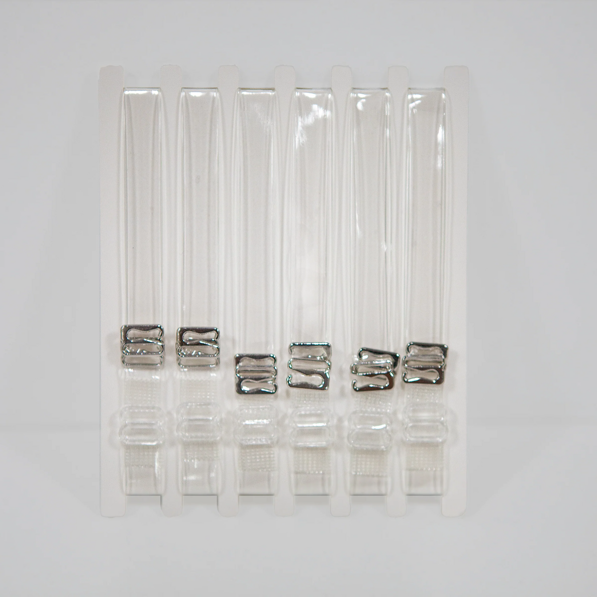 Set of clear straps in a clear plastic packaging on a white background