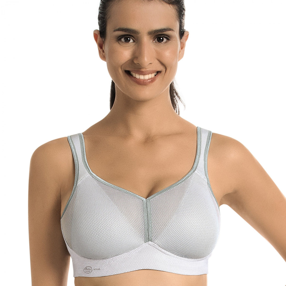woman wearing a white Lightweight, breathable sports bra with patented DeltaPad cups and strong support for high-impact activity.