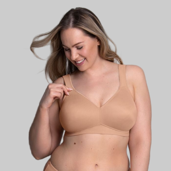 Woman wearing a beige bra against a gray background