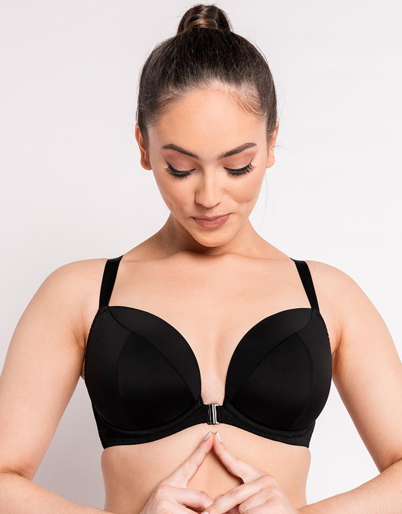 Woman wearing a black bra against a plain background