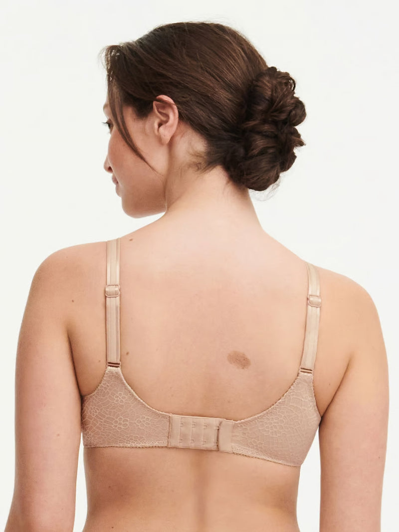 back view of a woman wearing a beige Chantelle C Magnifique seamless unlined minimizer bra with full-coverage cups and smoothing mesh band