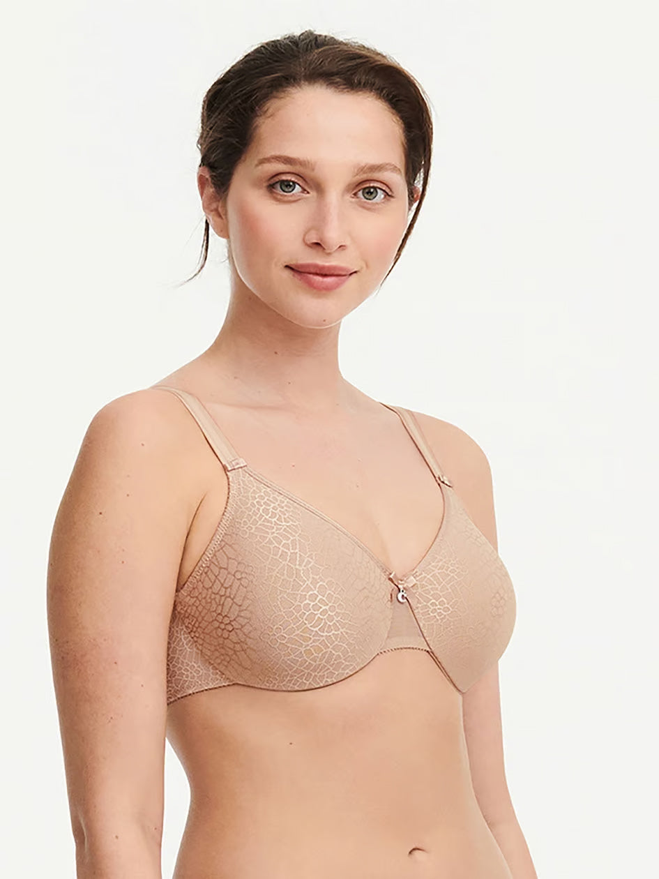 woman wearing a beige Chantelle C Magnifique seamless unlined minimizer bra with full-coverage cups and smoothing mesh band