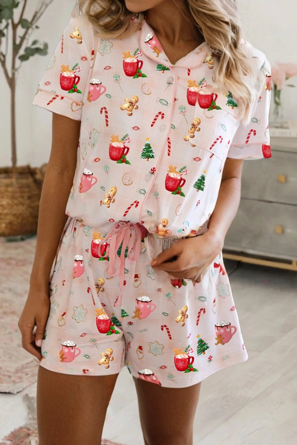 Woman wearing Christmas holiday print short pajama set with relaxed top and matching shorts