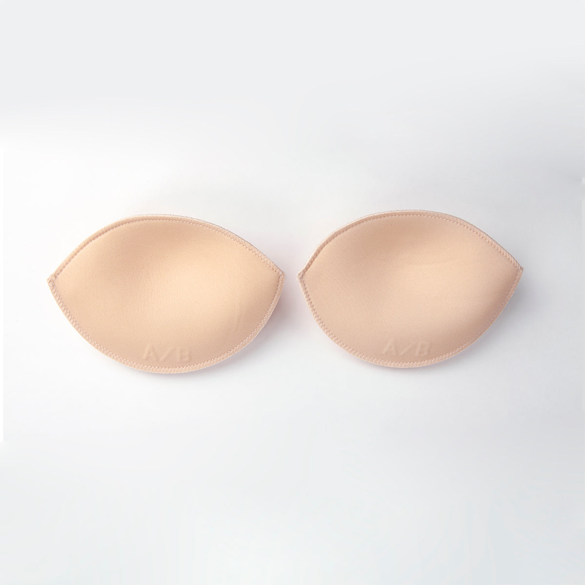 Beige silicone bra pads on a white background