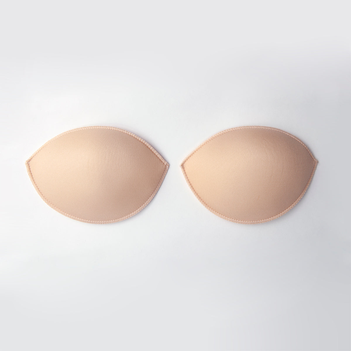 Beige bra pads on a white background