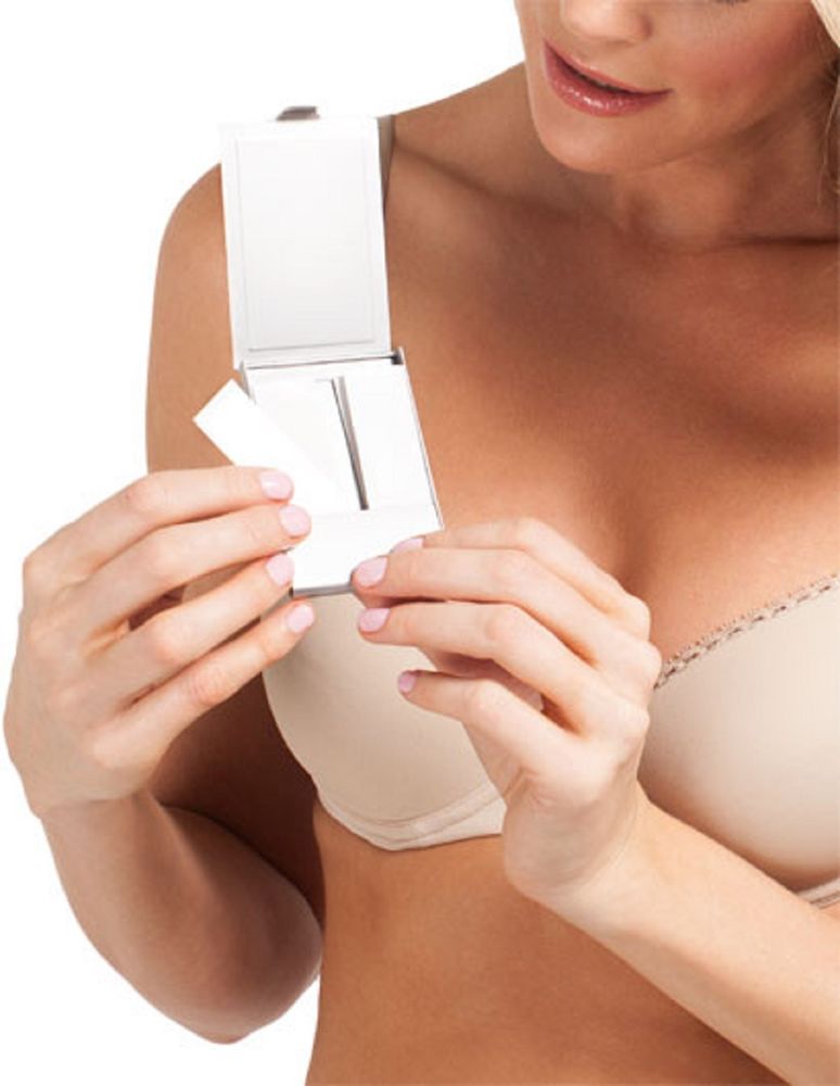 Woman holding a white device against her chest, possibly for measurement or inspection.