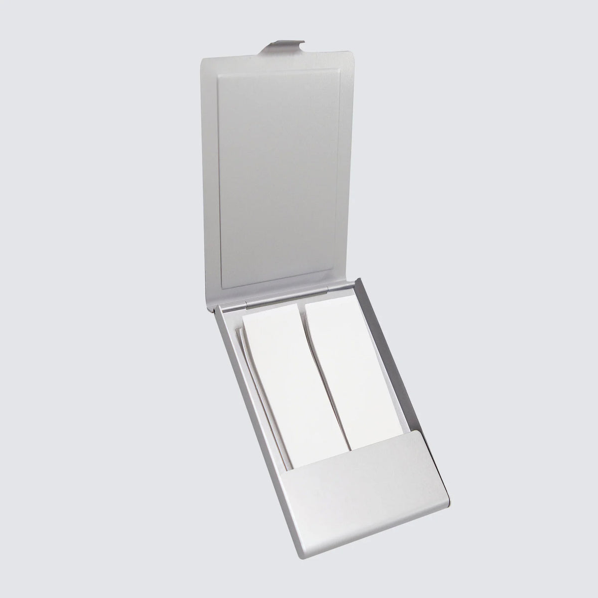 Compact mirror with a white case on a light gray background