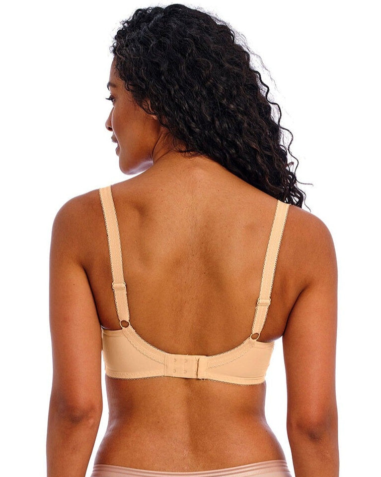 Woman wearing a beige bra and underwear set on a white background