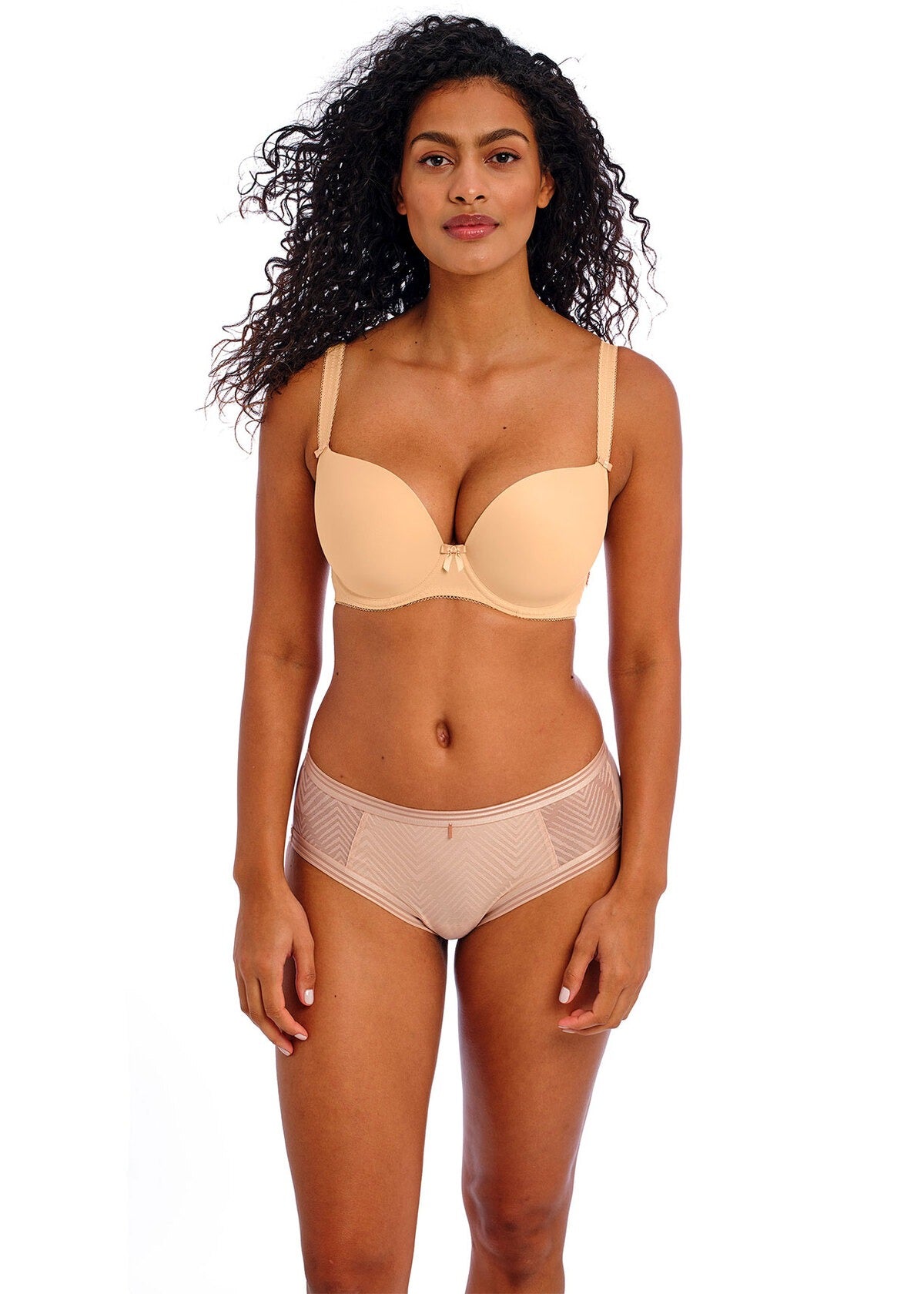 Woman wearing a beige bra and panties set on a white background