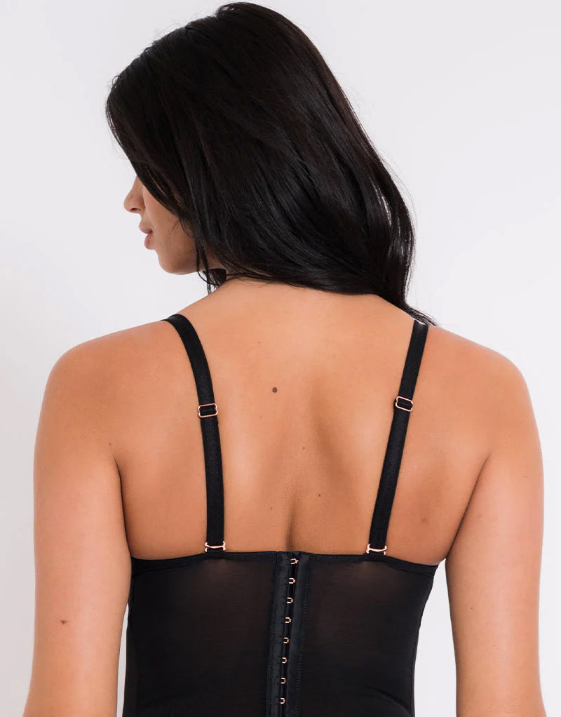 Woman wearing a black strappy top on a white background