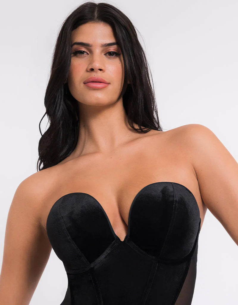 Woman wearing a black strapless top against a white background