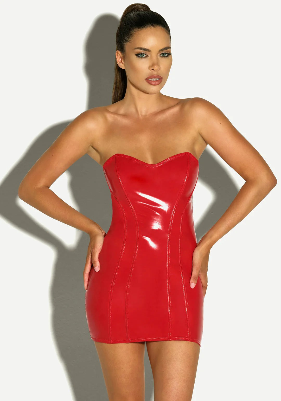 Woman wearing a red strapless dress against a plain background