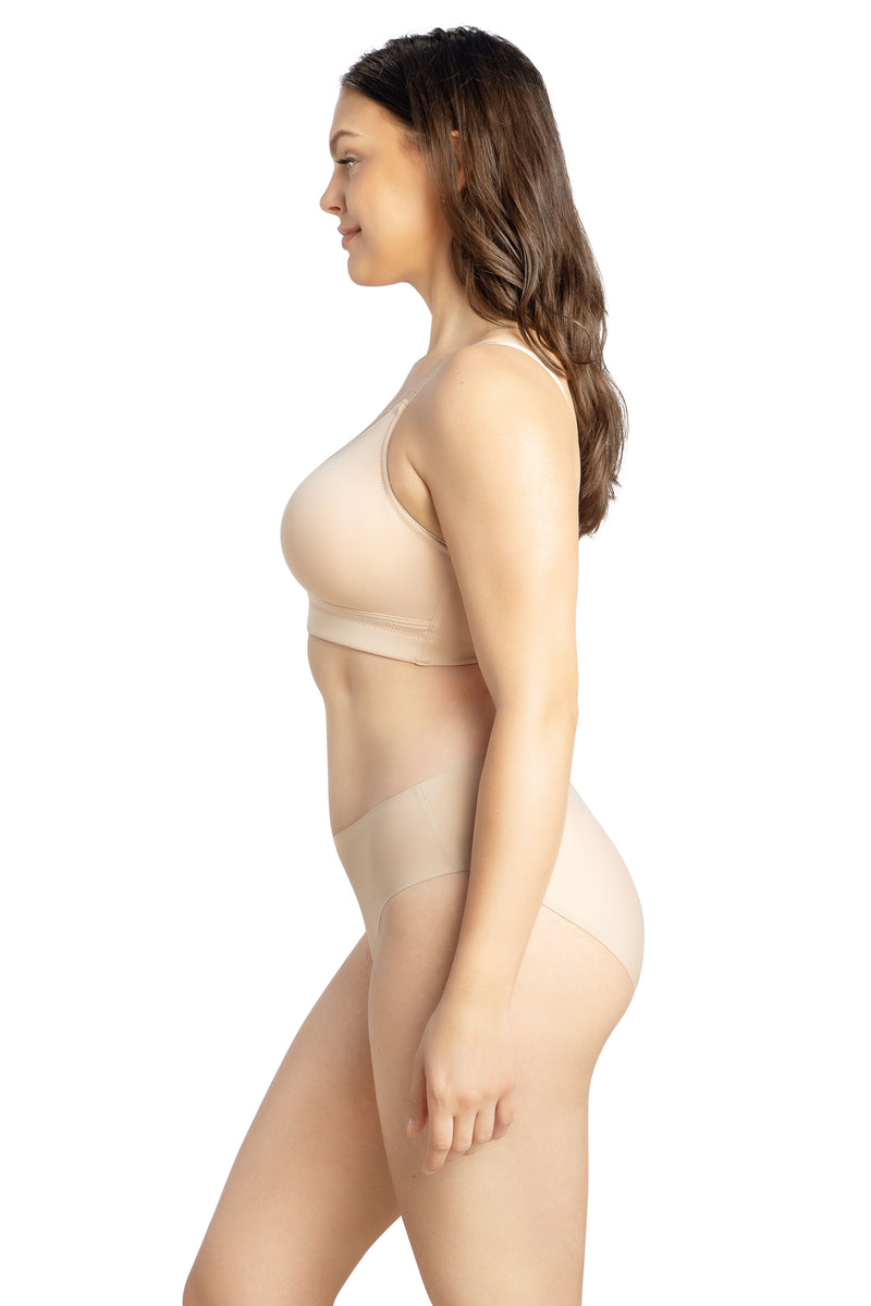 Woman wearing a beige bralette on a white background