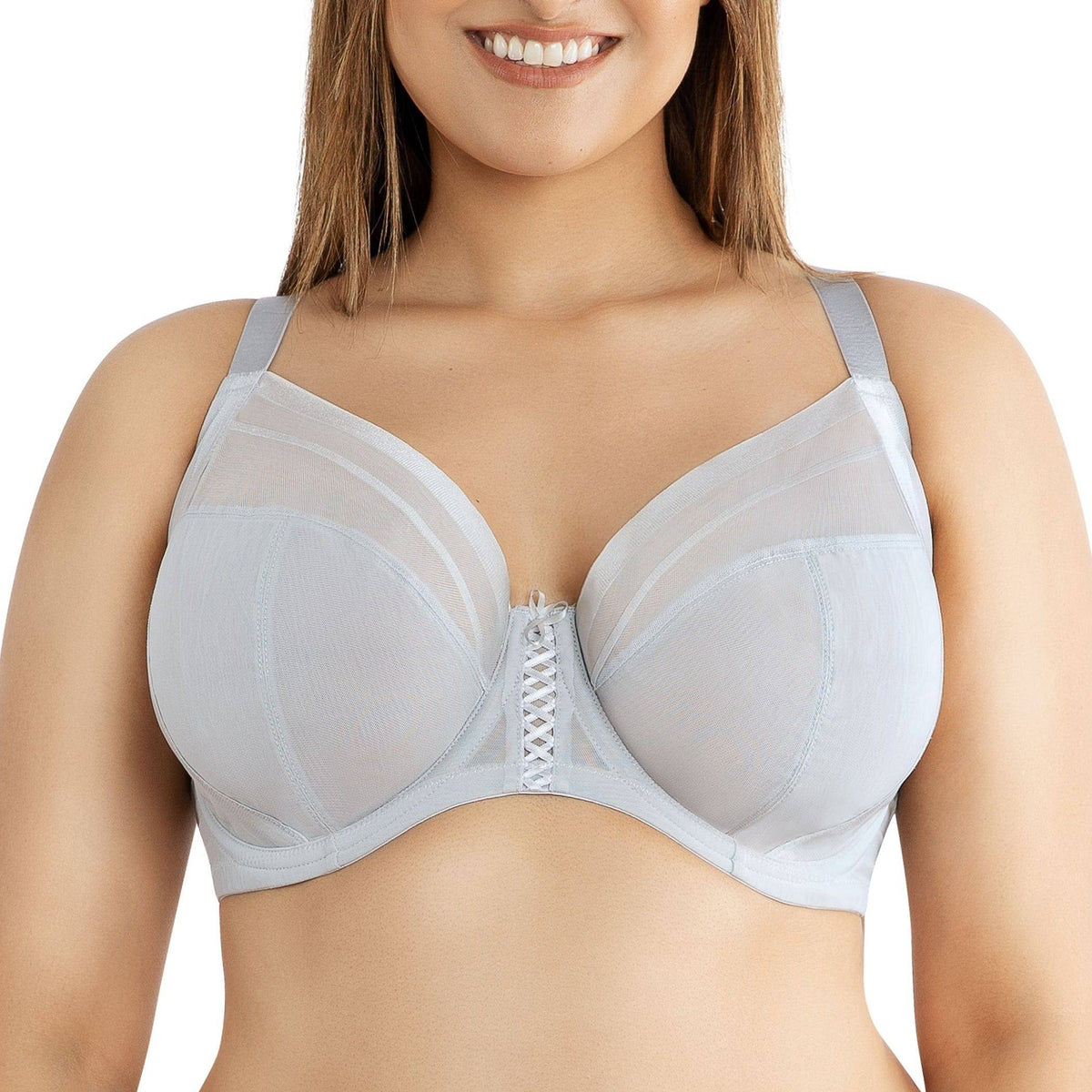 Woman wearing a light blue bra with mesh panels on a white background