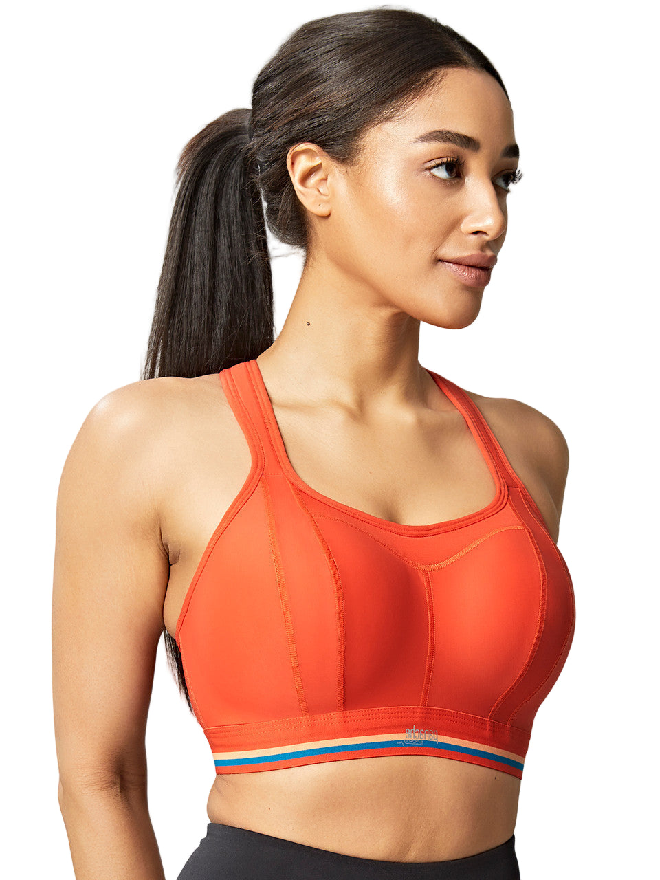 Woman wearing an orange sports bra with a gray background