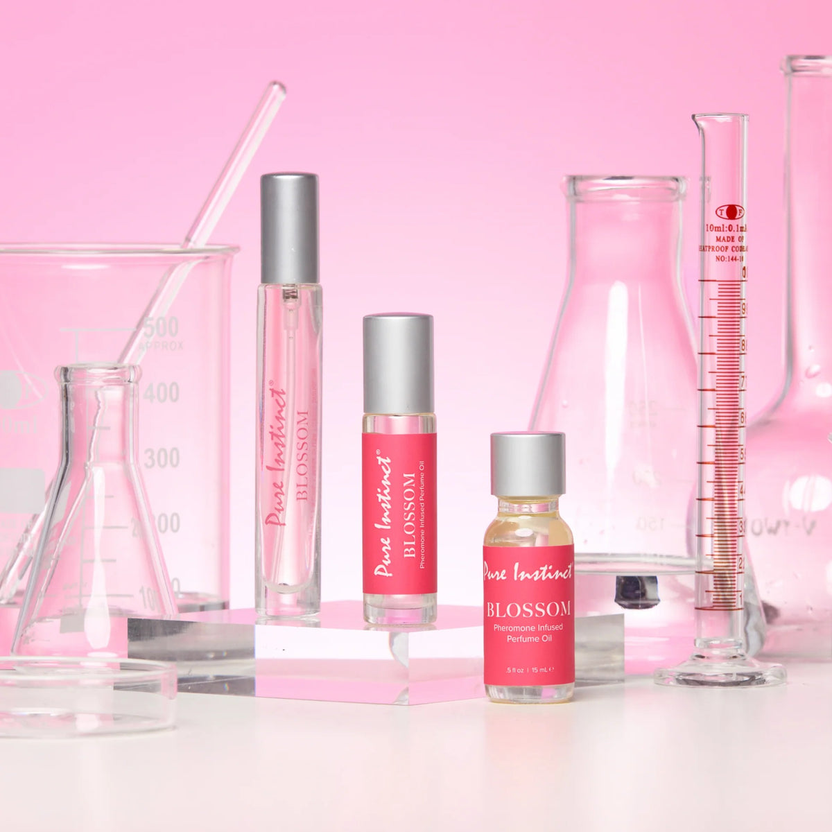 Set of perfume bottles with pink labels on a pink background