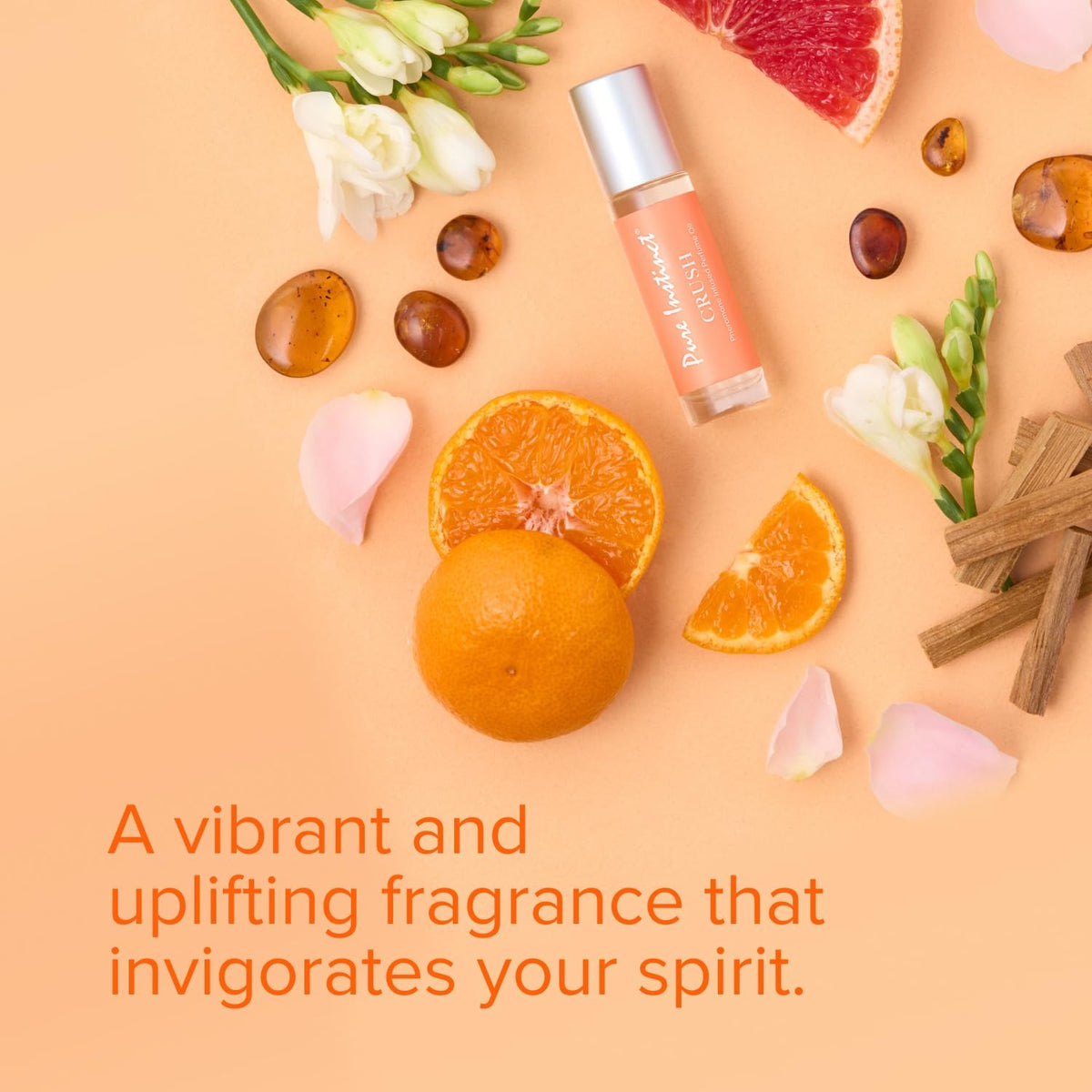 Roll-on bottle with orange slices, flowers, and essential oils on a peach background