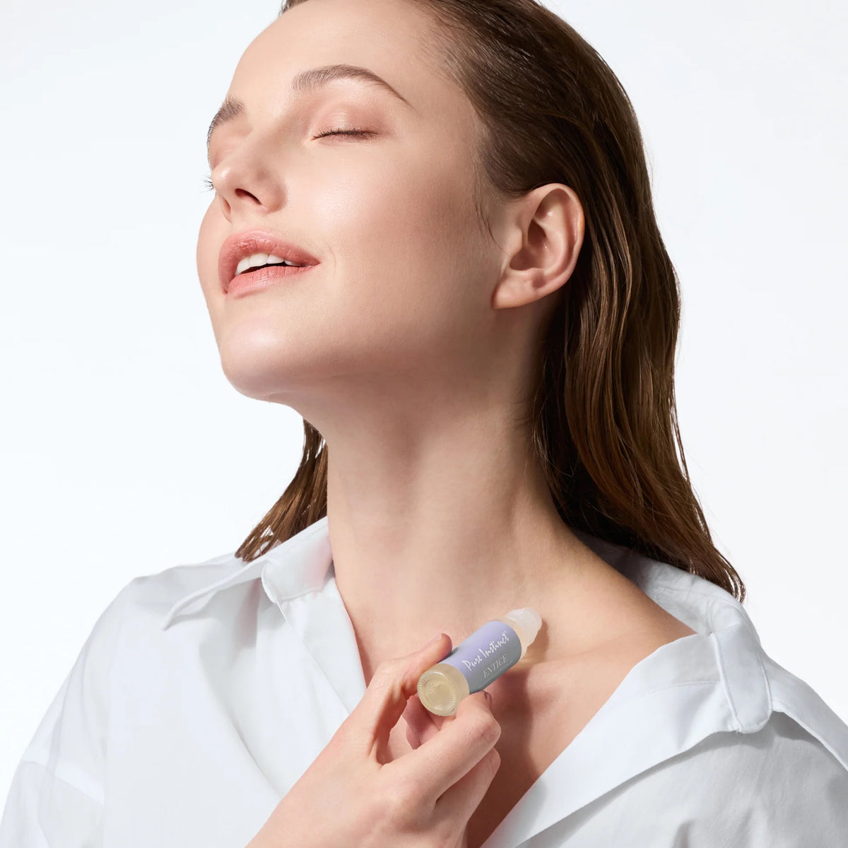 Woman applying a skincare product to her neck with a white background