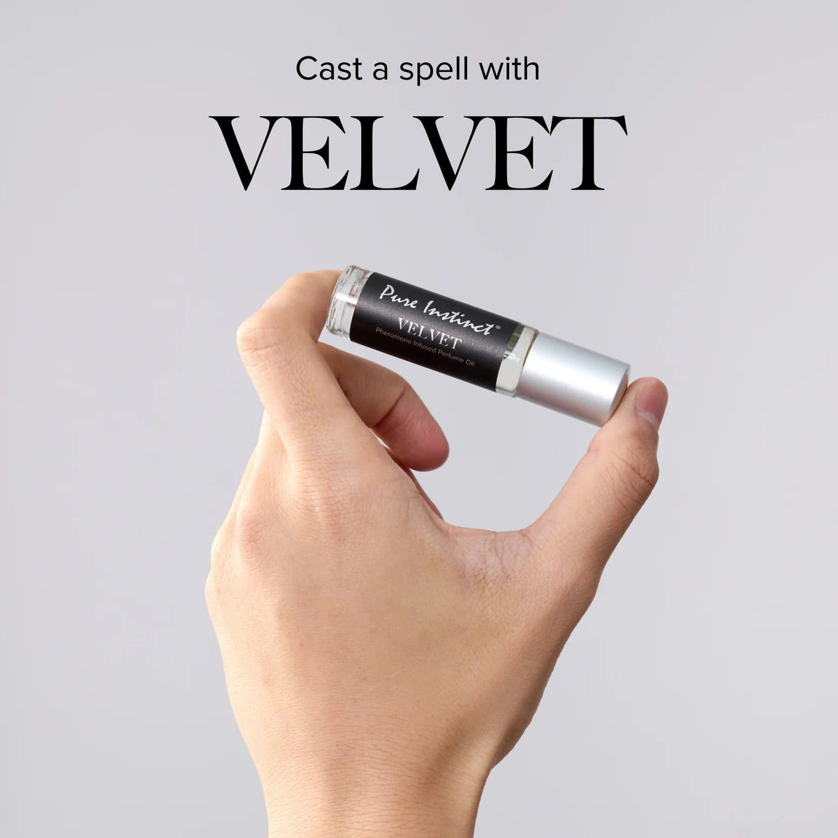 Hand holding a rollerball bottle labeled 'Velvet' against a gray background with text.