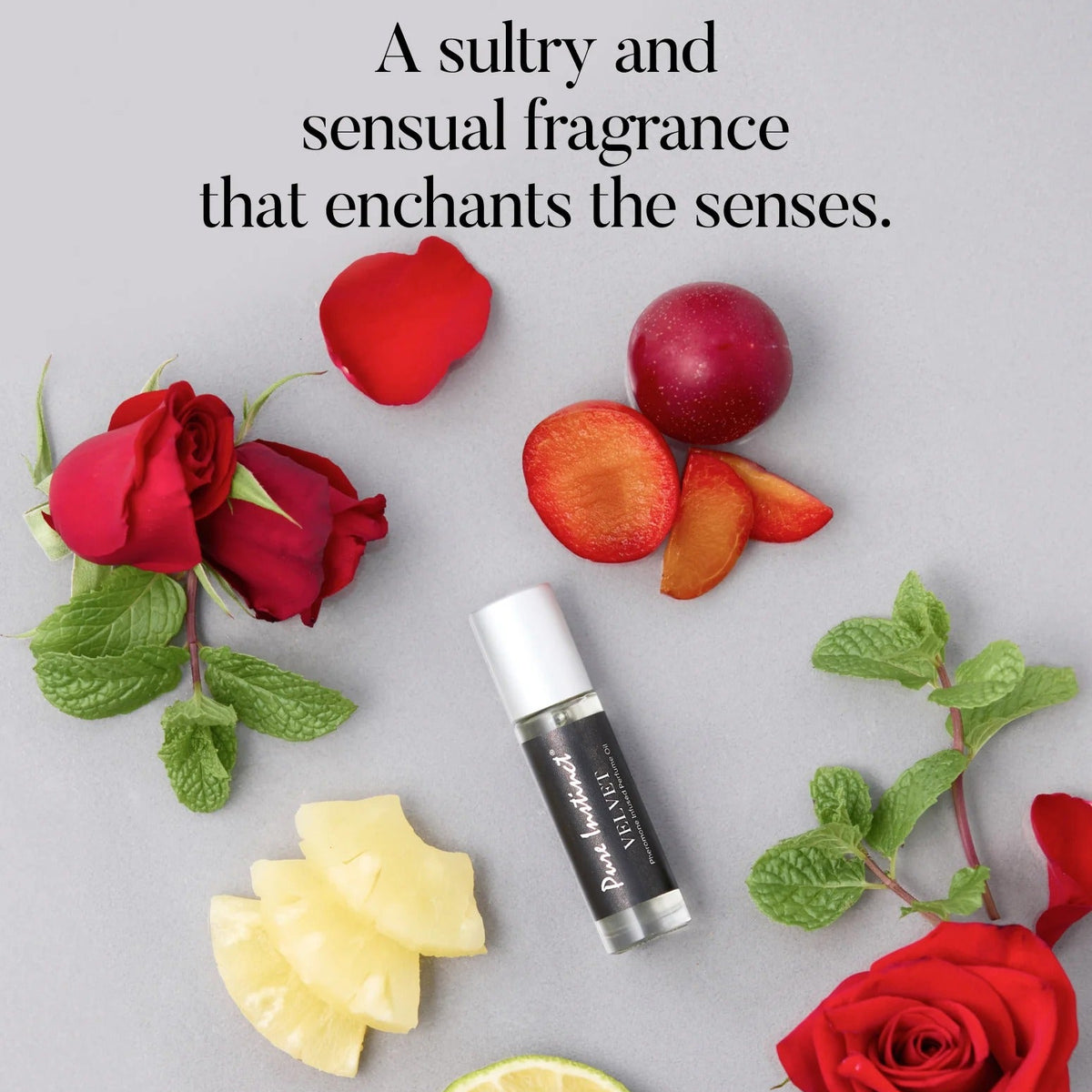 Perfume bottle surrounded by red roses, sliced apples, and lemon slices on a gray background with text about fragrance.