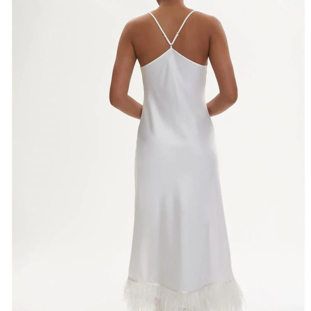 White slip dress with thin straps on a plain background