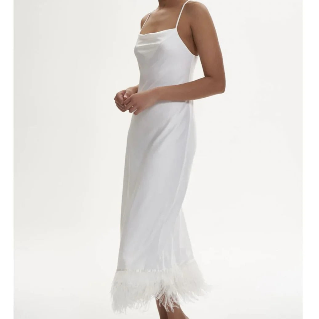 White slip dress with fringe hem on a white background