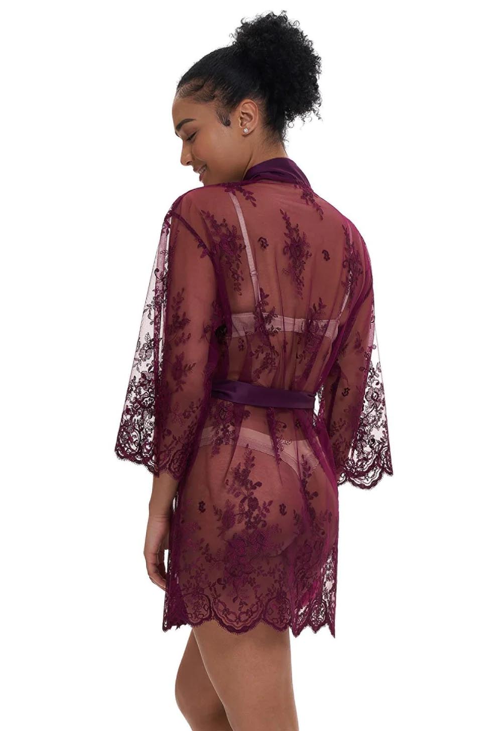 Woman wearing a burgundy lace robe on a white background