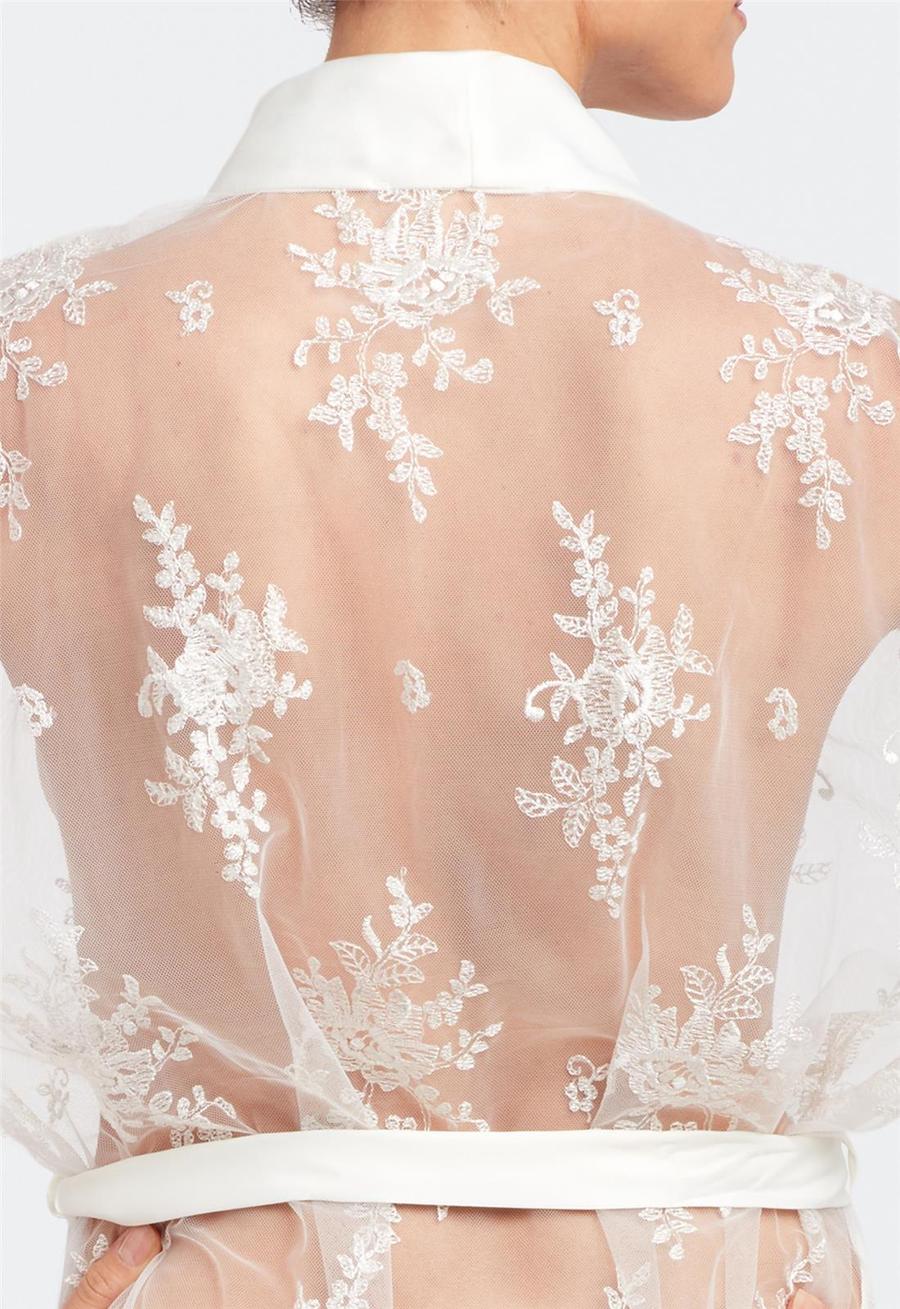 White lace sheer overlay with floral patterns on a plain background