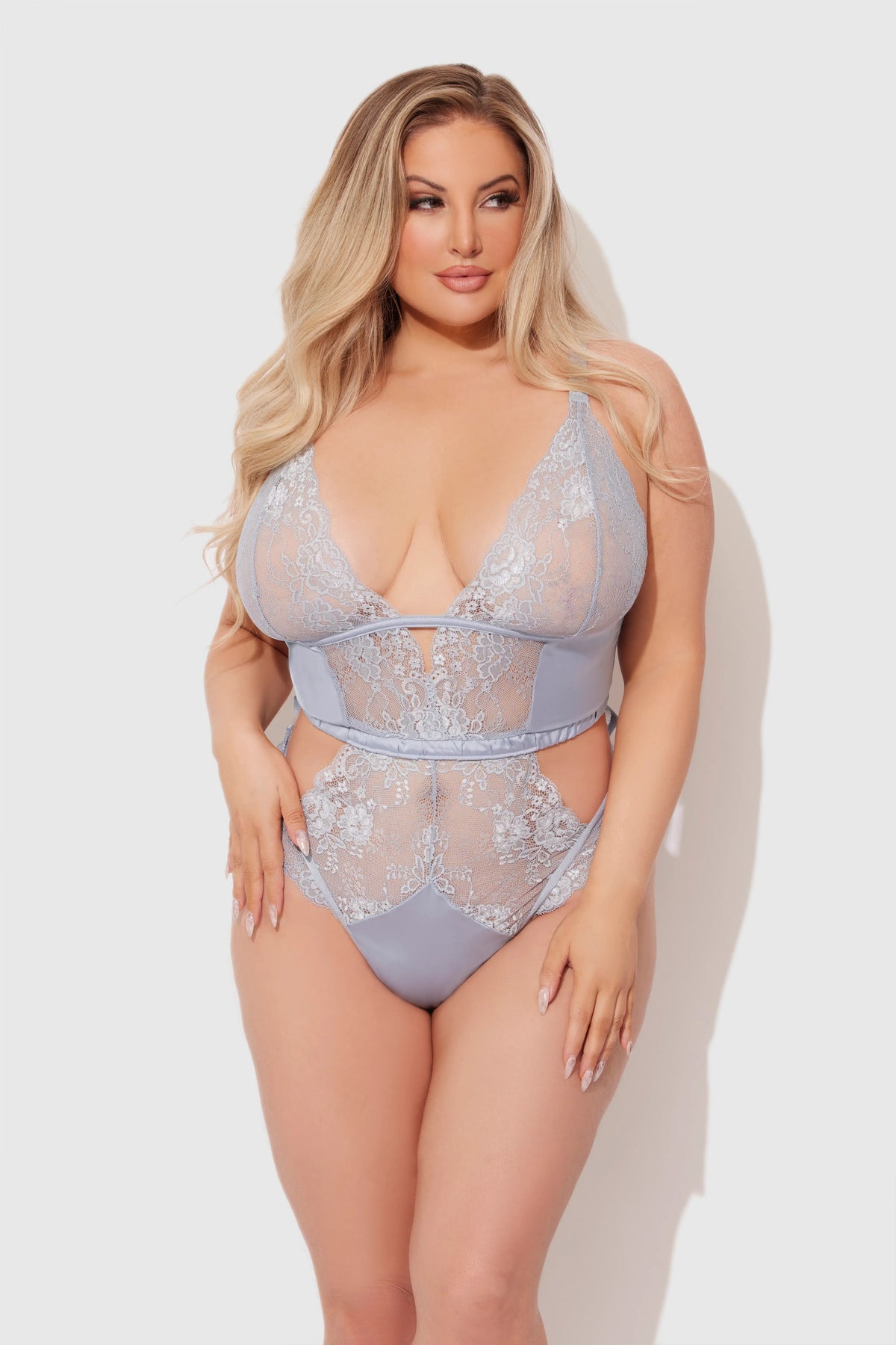 Woman wearing a light blue lace lingerie set on a white background