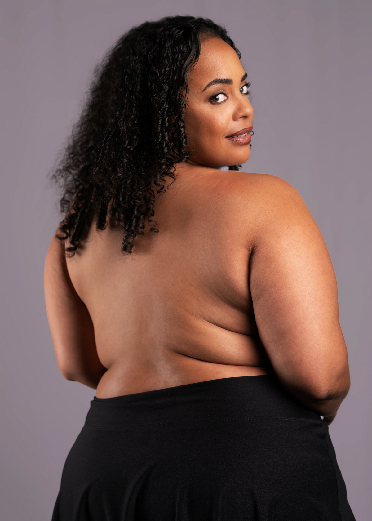 Woman with a black top against a gray background