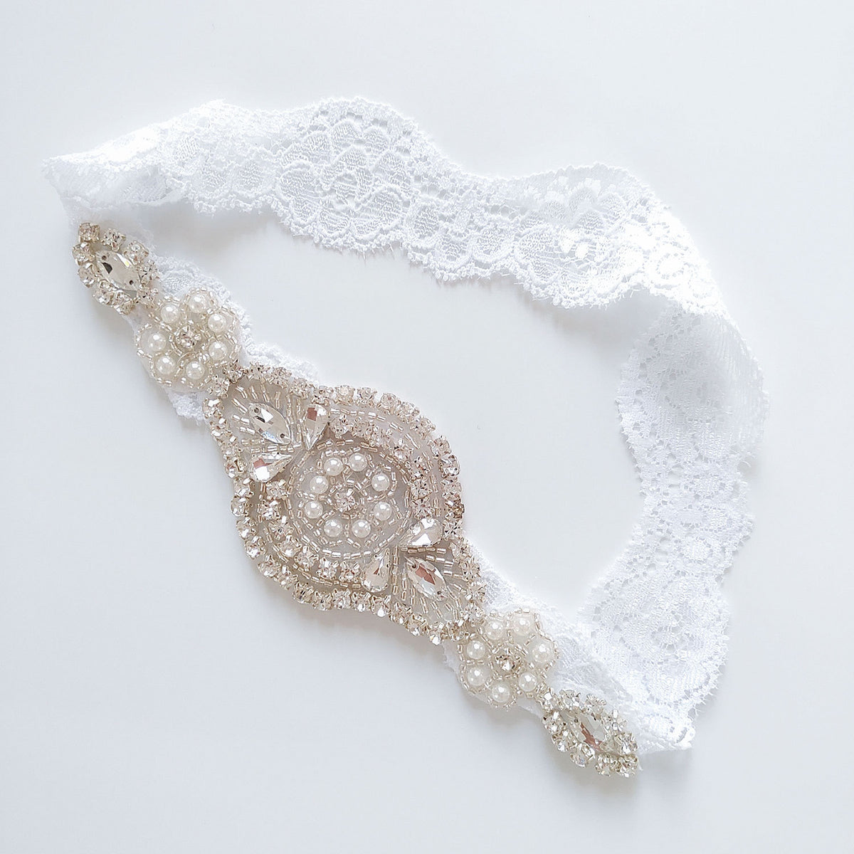 Decorative belt with pearls and crystals on a white lace background