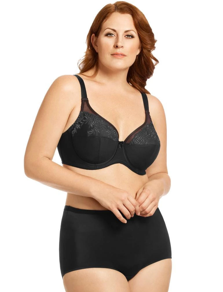 Woman wearing a black lace bra and panties set on a white background