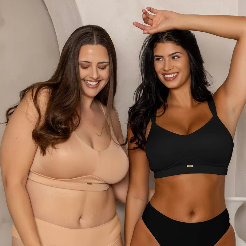 Two women wearing different types of bras against a neutral background