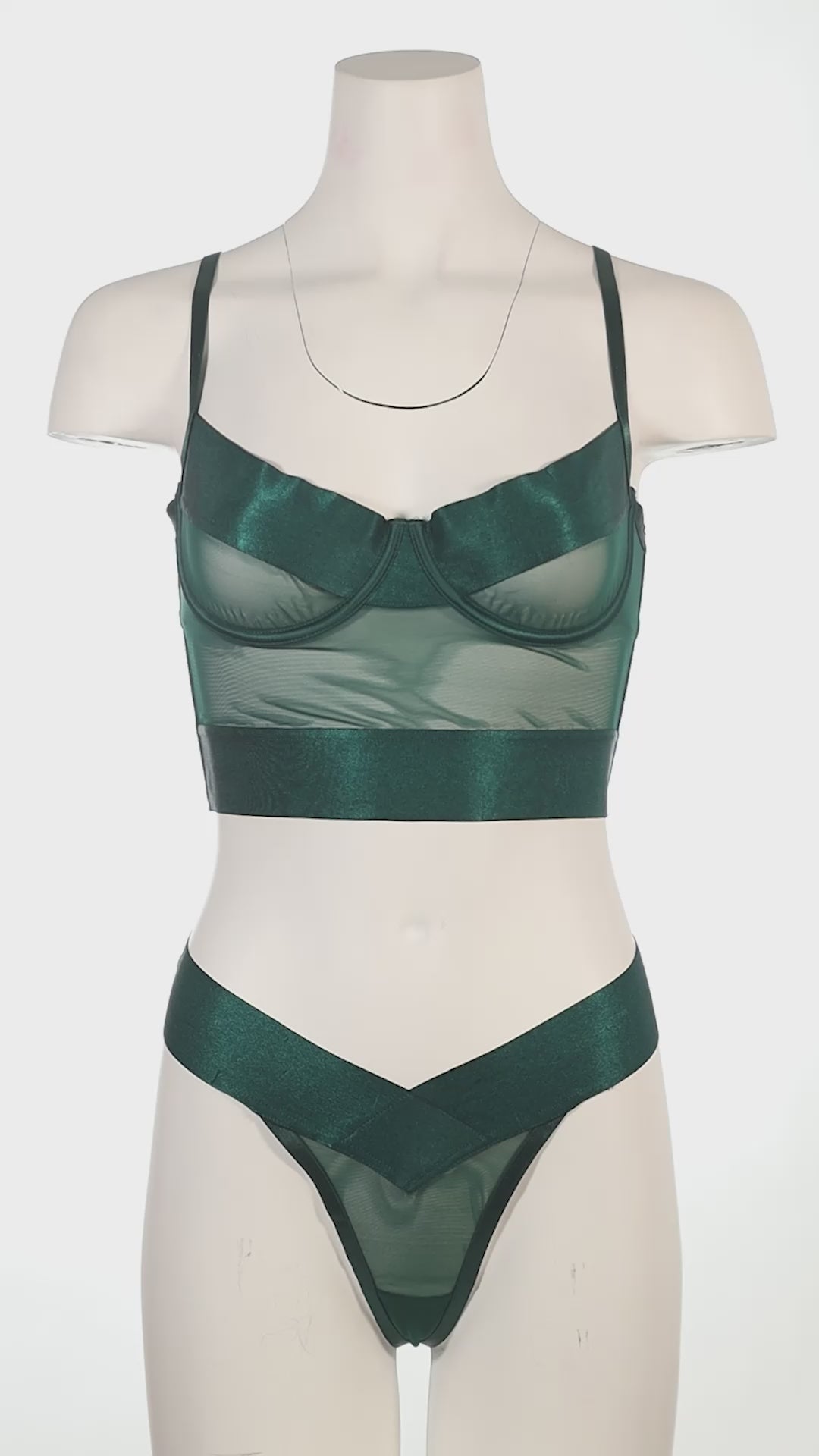 Mannequin wearing a green lingerie set against a white background
