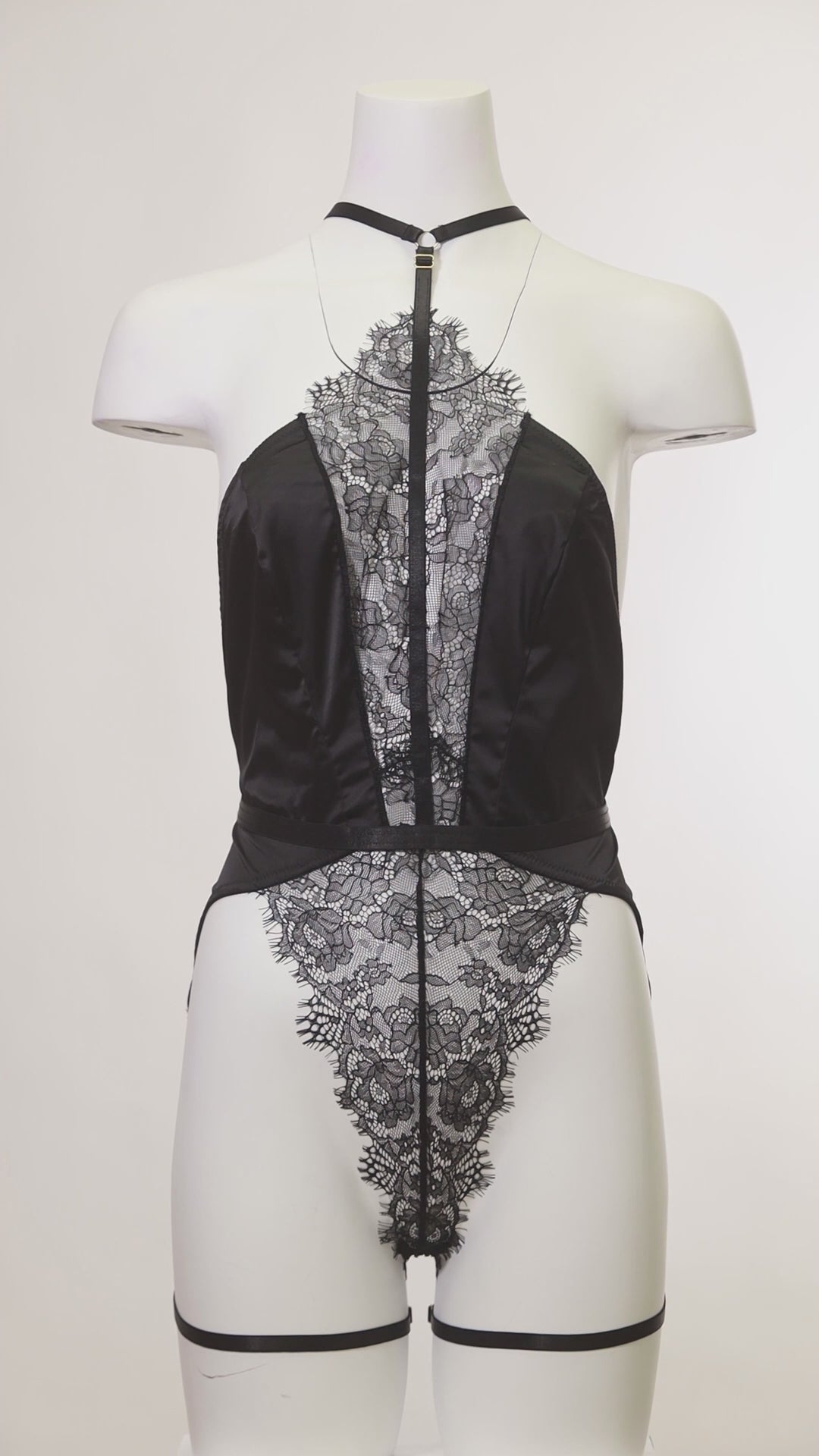 Mannequin wearing the Winnie Harness Lace Teddy featuring satin choker harness and lace body.