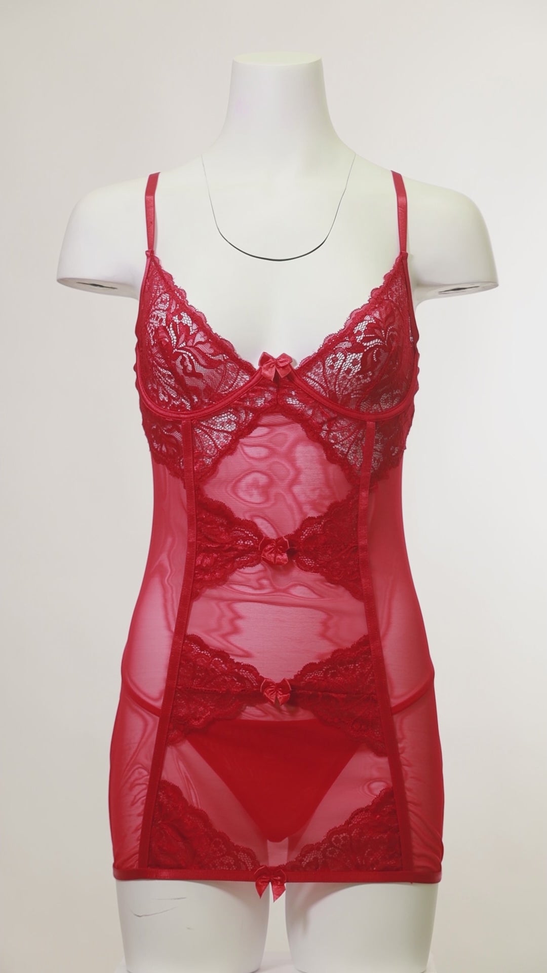Mannequin wearing a fitted lace and mesh babydoll with bow details and matching G-string