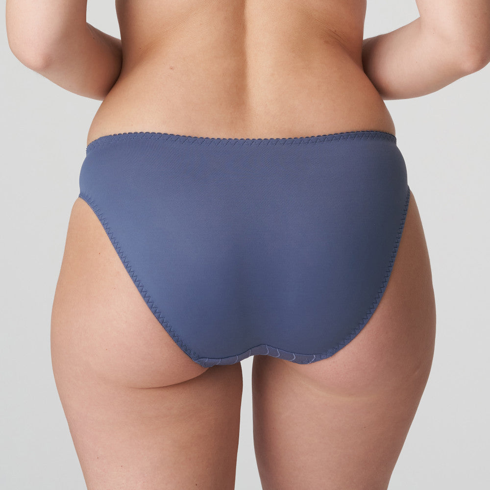 Person wearing a blue underwear on a plain background