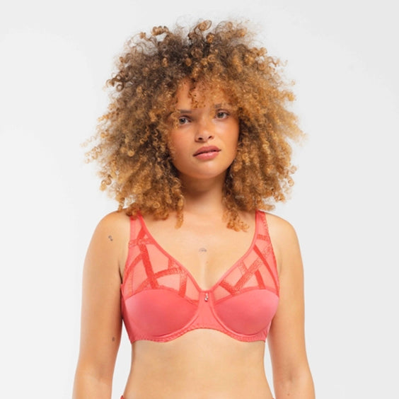 Woman wearing a pink bra against a plain background